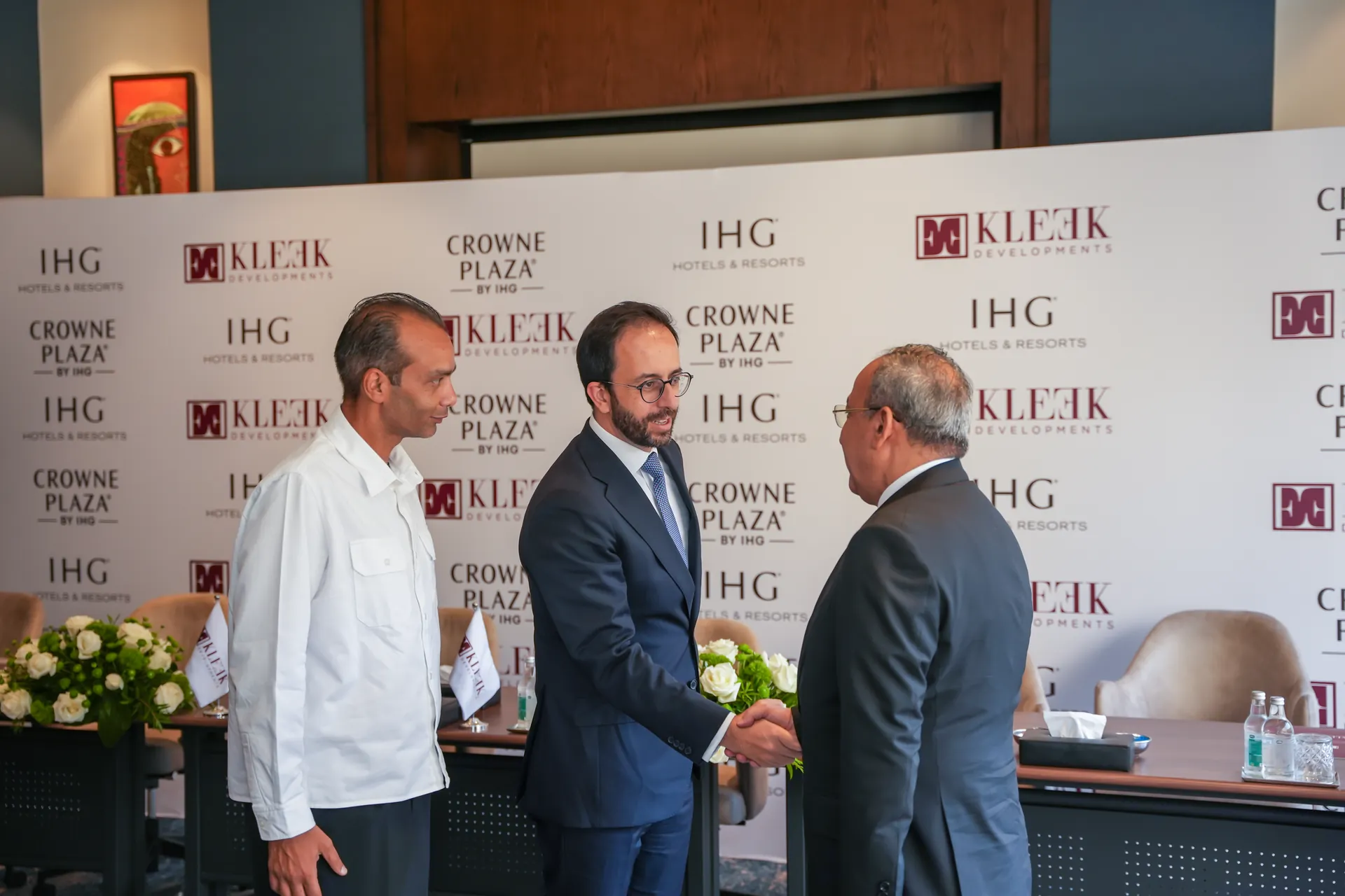 kleek ihg crowne plaza signing ceremony 01 executives handshake